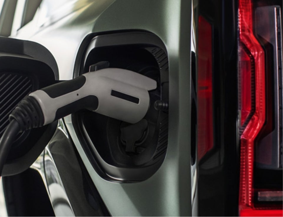 Close up of charging port with charger plugged in on a GMC Hummer EV SUV - Fury GMC Forest Lake in FOREST LAKE MN